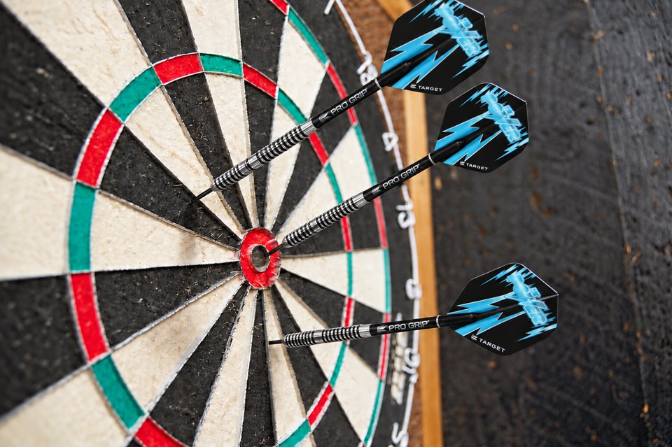 Three cyan-flight darts in a well-used dartboard
